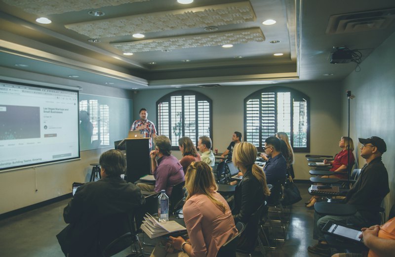 Turma acompanhando uma aula com projeção em sala de treinamento